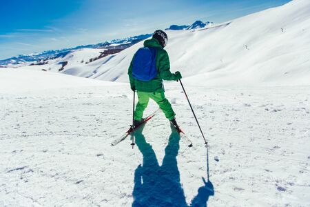Young athlete freestyle Skier having fun while running downhill in beautiful landscape on sunny day...