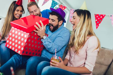 Young group of happy friends celebrating birthday at home and having fun.の写真素材