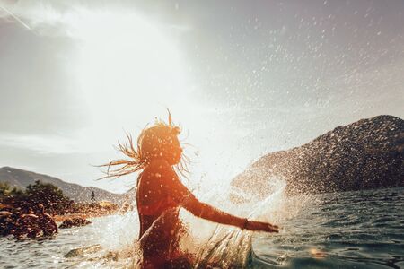 Girl jump off the pier into the sea. Selective focusの写真素材