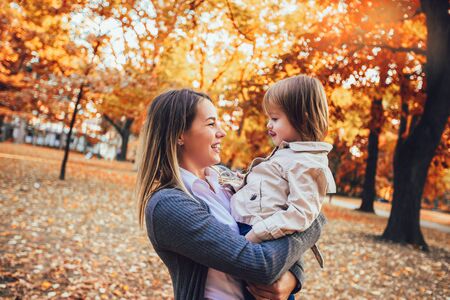Mother and daughter in the park enjoying the beautiful autumn nature.の写真素材