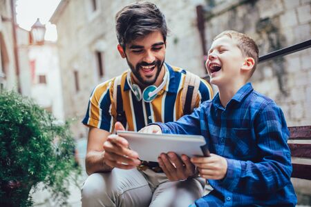 Portrait of man with son using digital tabletの写真素材