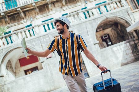 Handsome bearded tourist with backpack is making travel across city.の写真素材