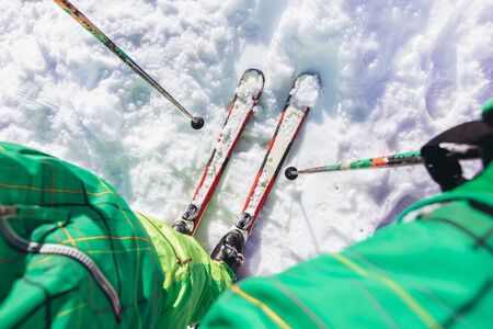 Man on ski standing on the snow on ski piste at sunny day in mountainsの写真素材