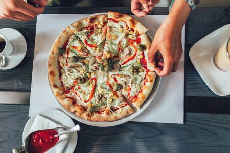 Close-up of human hand holding slice of pizzaの写真素材