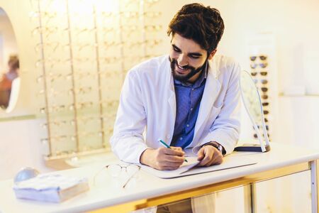 Confident optometrist, optician standing in store.の写真素材