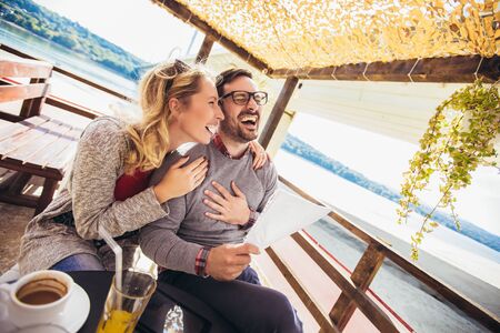 Beautiful loving couple sitting in a cafe enjoying in coffee and conversation.