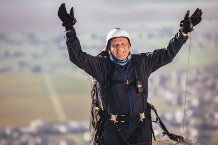 Senior paraglider on the ground prepairs to fly.の写真素材
