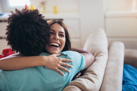Happy couple with gift box hugging at home