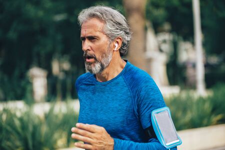 Active senior man jogging on a sunny dayの写真素材