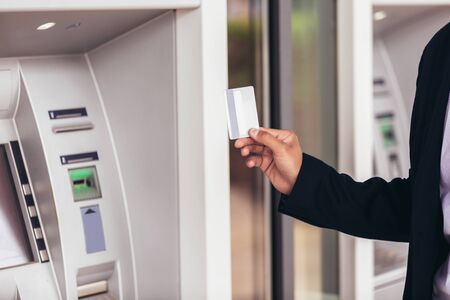 Young business man using ATM. Person using credit card to withdrawing money from atm machine.の写真素材