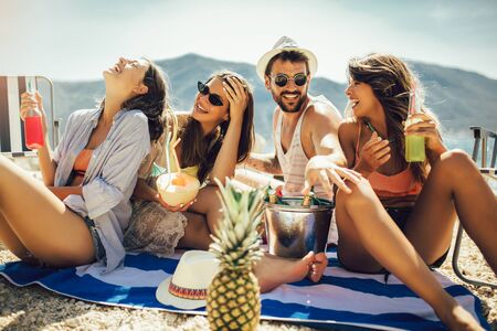 Young friends having fun at the beach on a sunny day. Party time.の写真素材