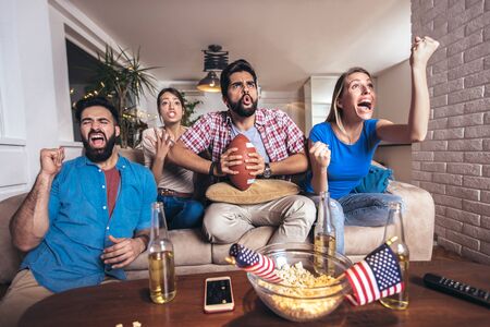 Group of friends sport fans watching rugby match victoryの写真素材