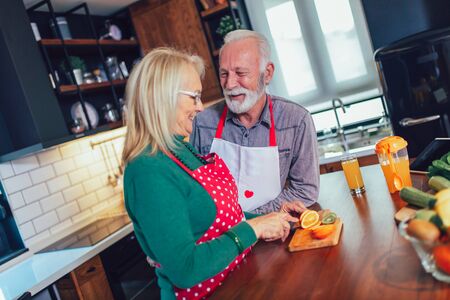 Senior couple preparing food in the kitchen.の写真素材