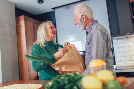 Senior couple preparing food in the kitchen.の写真素材