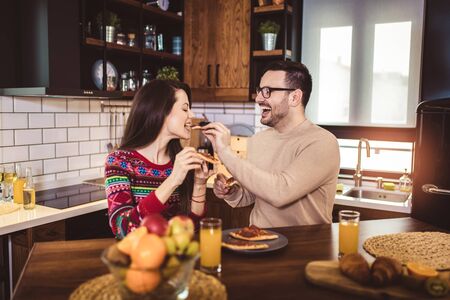 Young couple enjoying eating pizza at home.の写真素材