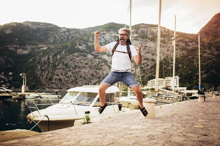 Smiling tourist mature man having fun near the sea.の写真素材