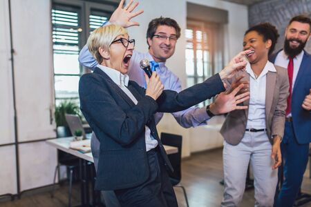 Funny teambuilding indoors activity. Business people making team training exercise during team...
