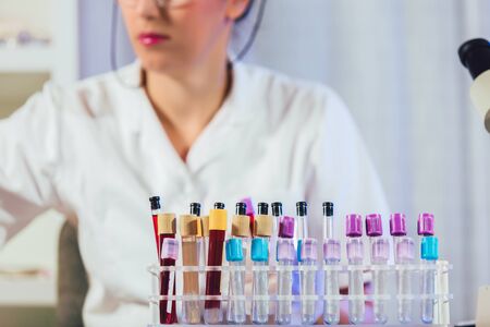 Lab technician assistant analyzing a blood sample in test tube at laboratory. Medical, pharmaceutical and scientific research and development concept.の写真素材