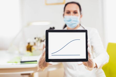Female doctor uses a digital tablet and displays disease statistics on the screen.の写真素材