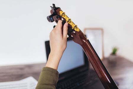 Close up of fingers holding guitar pegs. Close up of fingers tightening guitar pegsの写真素材