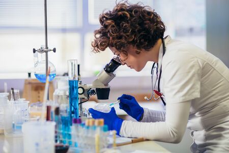 Lab technician assistant analyzing a blood sample at laboratory. Medical, pharmaceutical and...