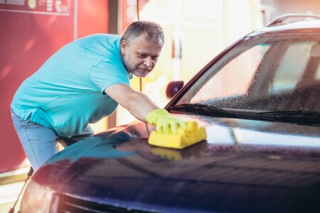 Car washing. Cleaning car using washing sponge.の写真素材