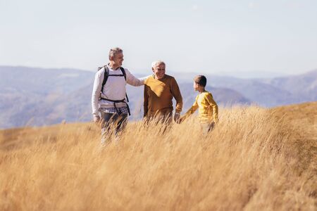 Three generations of family hiking together in the autumn.の写真素材