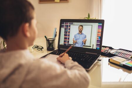 Distance learning online education. A schoolboy boy studies at home and does school homework. A home...