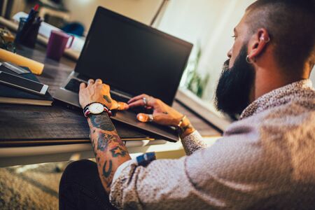 Young man working on his laptop computer at homeの写真素材