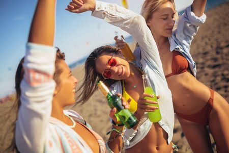 Group of three beautiful attractive young women having fun on the beach.の写真素材