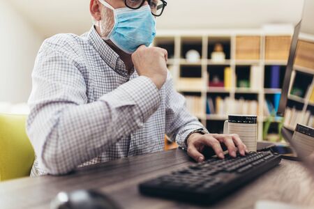 Business man working from home, wear a protective mask. Quarantine due coronavirus pandemic. Stay at home.の写真素材