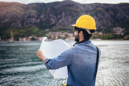 Harbor engineer holding the paper, construction work, smiling.の写真素材