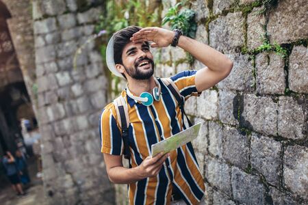Handsome bearded tourist with backpack is making travel across city.の写真素材