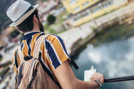 Handsome bearded tourist with backpack is making travel across city.の写真素材