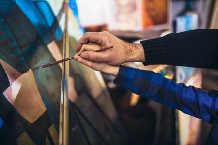 Father and son working and painting together in art studio, close up of hands.の写真素材