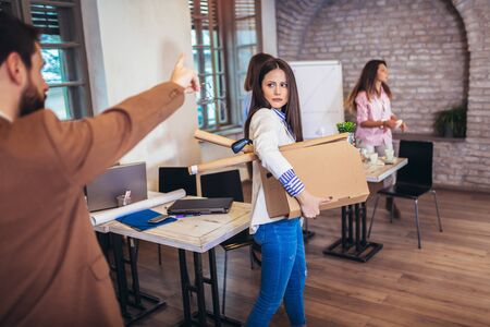 Business woman carrying packing up all his personal belongings and files into a brown cardboard box to resignation in modern office, resign concept.の写真素材