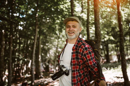 Mature man on a hiking trip through forest