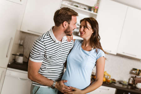 Pregnant woman with husband in the kitchen