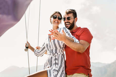 Loving couple spending happy time on a yacht at sea. Luxury vacation on a seaboat.の写真素材
