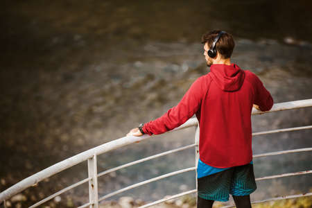 Man resting and enjoying some refreshment. Young male athlete taking a break from running.の写真素材