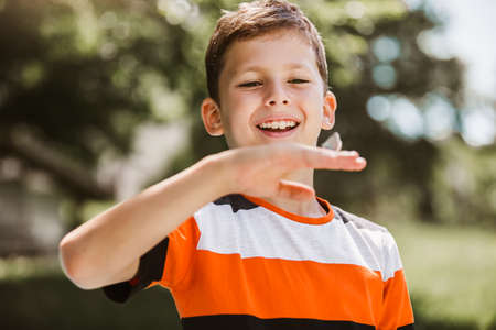 Butterfly in a child's hand. butterfly on a child's palm. Young boy exploring nature in a meadow.の写真素材