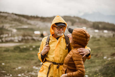 Middle age loving couple with backpack hiking in a beautiful natureの写真素材