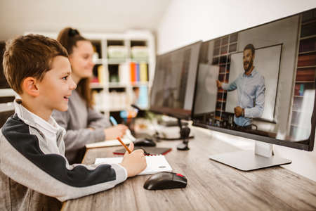 Boy and girl studies at home and doing school homework. Distance learning online education.の写真素材