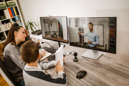 Boy and girl studies at home and doing school homework. Distance learning online education.の写真素材