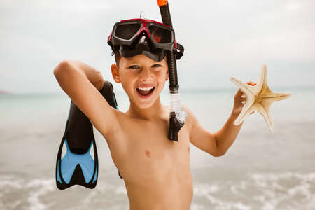 Child with mask and fins.  Little boy learning to dive.