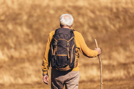 Senior man on hike through beautiful countryside in autumn.の写真素材