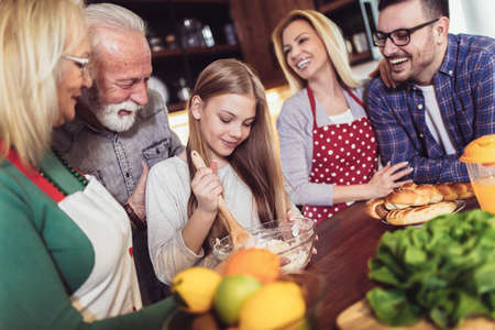 Three generation family in kitchen preparing lunch, having funの写真素材
