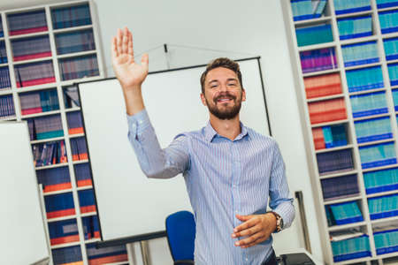 Portrait of smiling male coach giving presentation for audience in lecture hallの写真素材