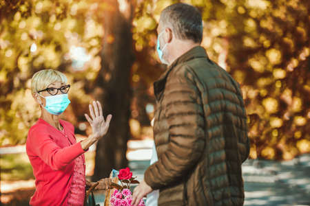 Senior people together in times of coronavirus social distancing in the park. New normal.の写真素材