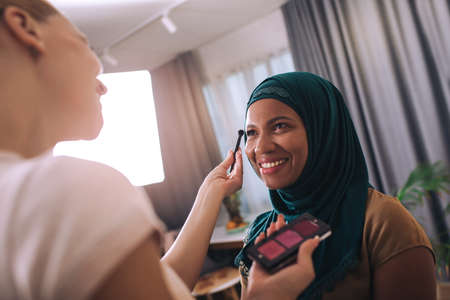A make-up artist makes up a Muslim woman at home.の写真素材
